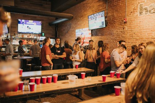 Free Energetic bar party with people socializing in Denver. Enjoyment and games in a lively pub atmosphere. Stock Photo
