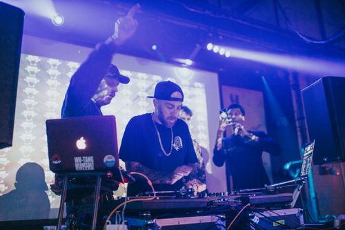 Free Energetic DJ spinning tracks at a live event in Denver nightclub with colorful stage lights. Stock Photo