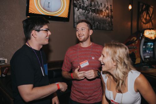 Free A group of friends laughing and chatting indoors at a casual social gathering. Stock Photo