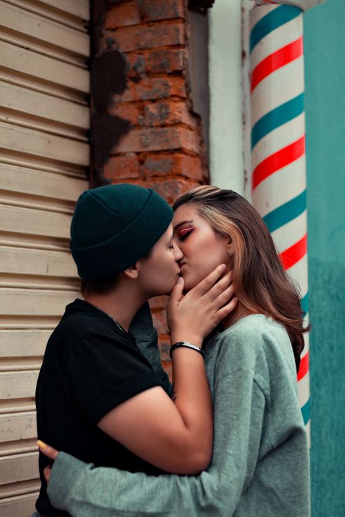 Free A couple sharing an intimate kiss outdoors, embodying love and affection in a romantic setting. Stock Photo