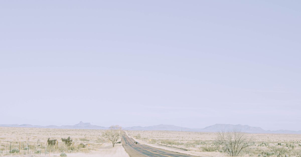 Expansive desert road in Marfa, Texas under clear sky. Perfect for travel and adventure themes.