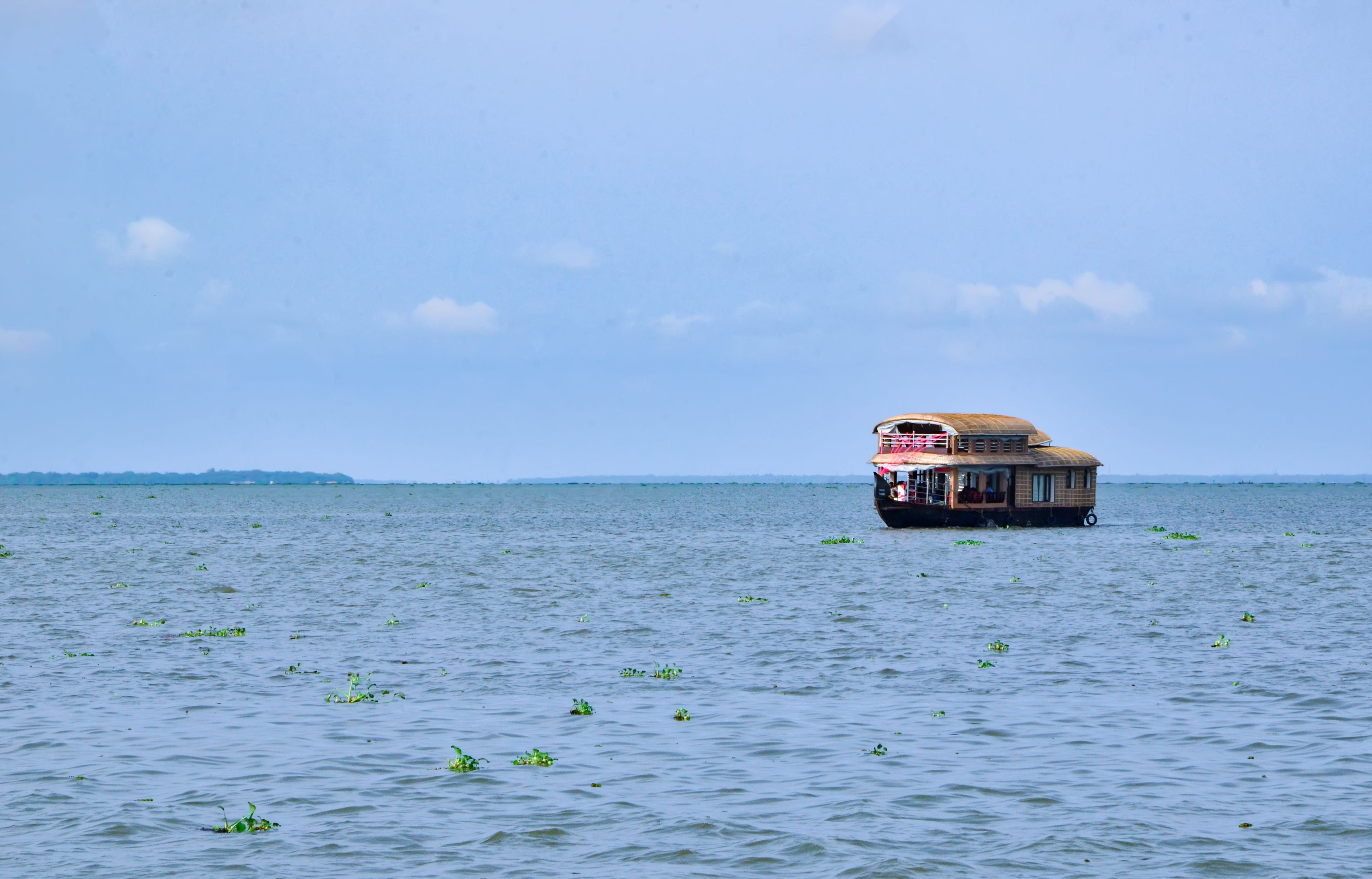 A traditional houseboat on the open waters of the Alappuzha backwaters