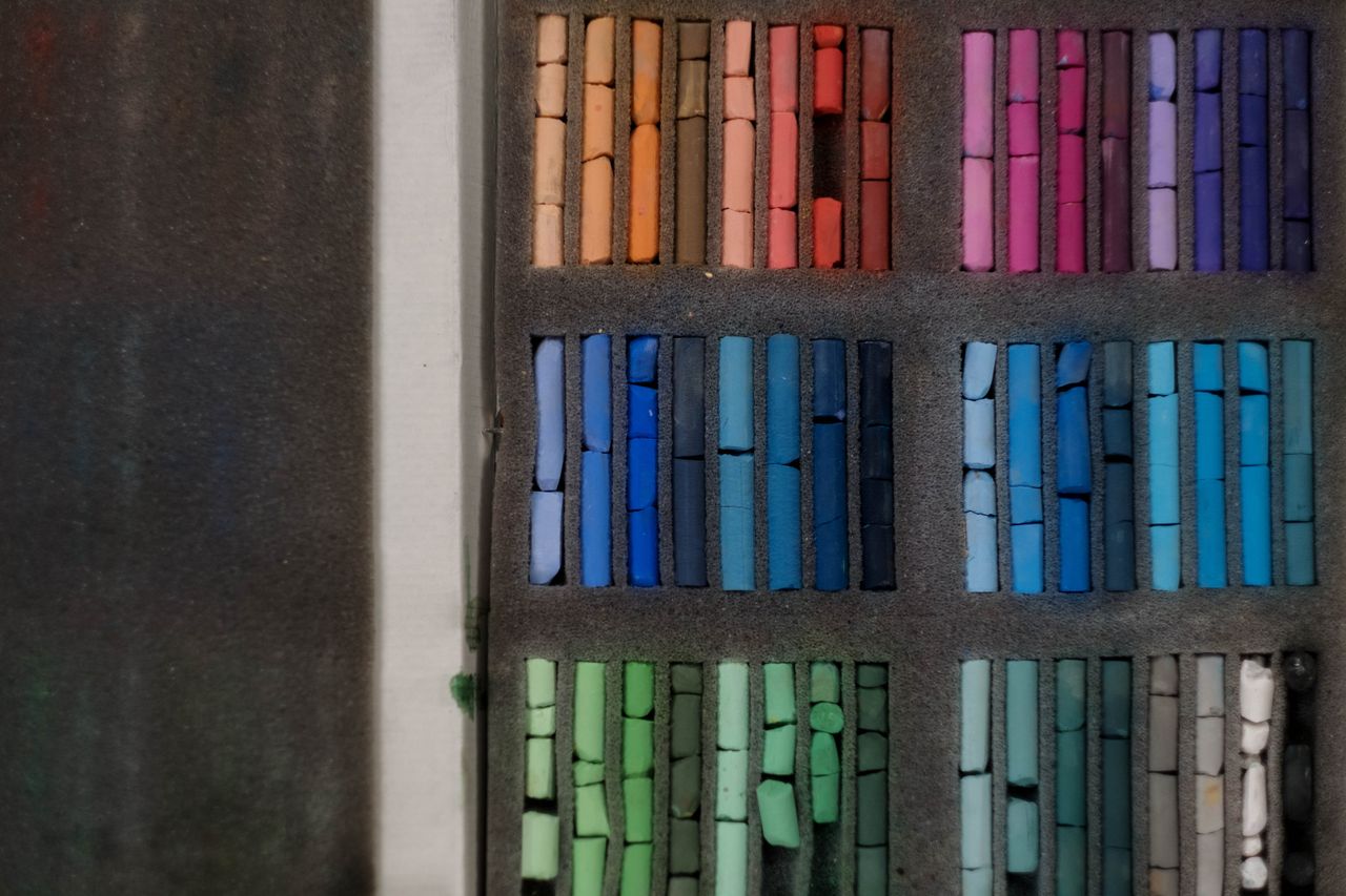 a neatly arranged set of colorful pastels in a display case showcasing