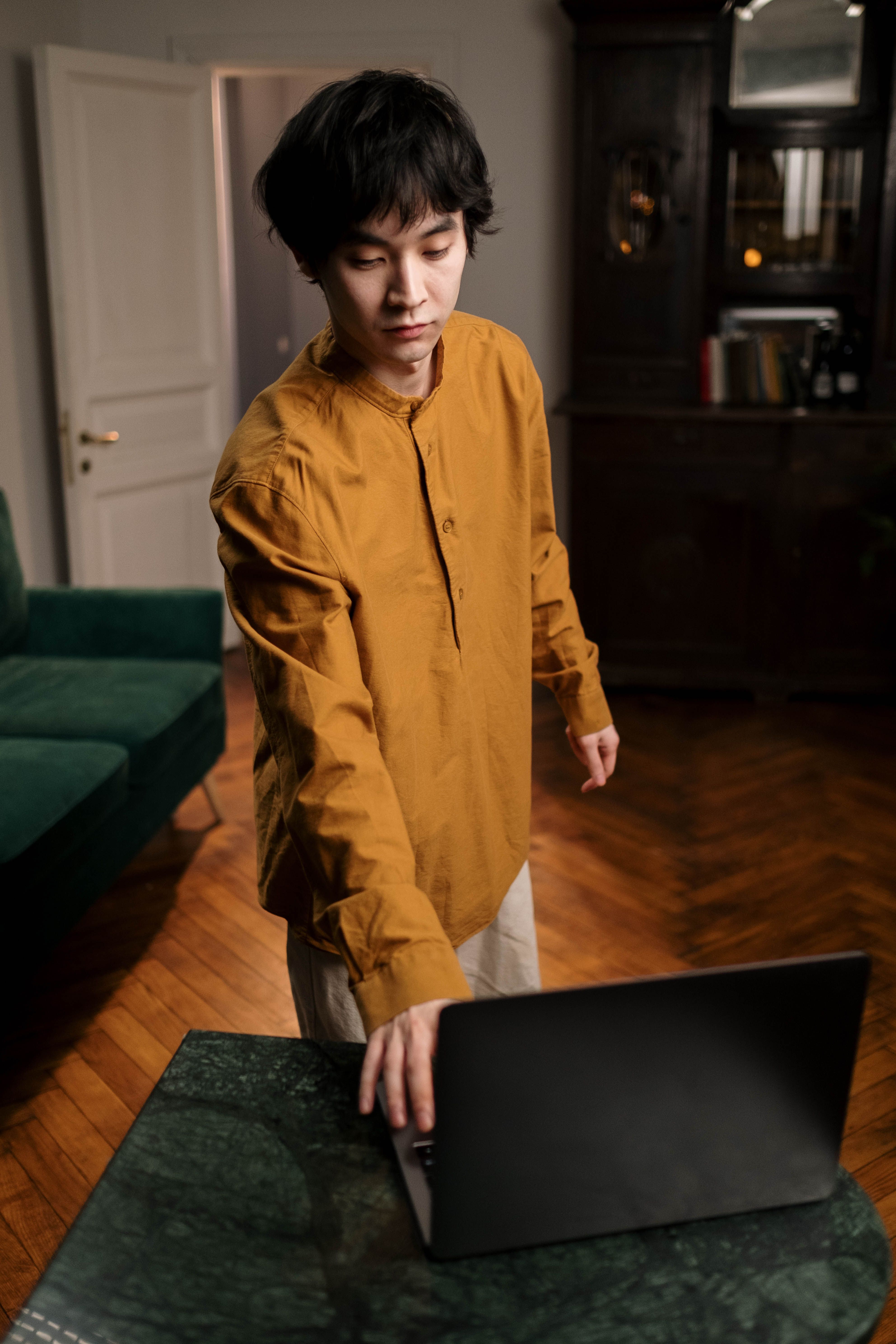 Photo of a Man in a Yellow Shirt Using His Laptop · Free Stock Photo