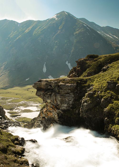 Free Flowing river through green mountains and rocky cliffs, taken in a beautiful outdoor setting. Stock Photo