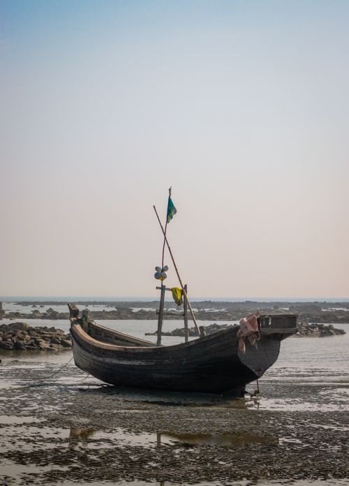 Free A traditional wooden fishing boat rests on Cox's Bazar beach in Bangladesh. Stock Photo