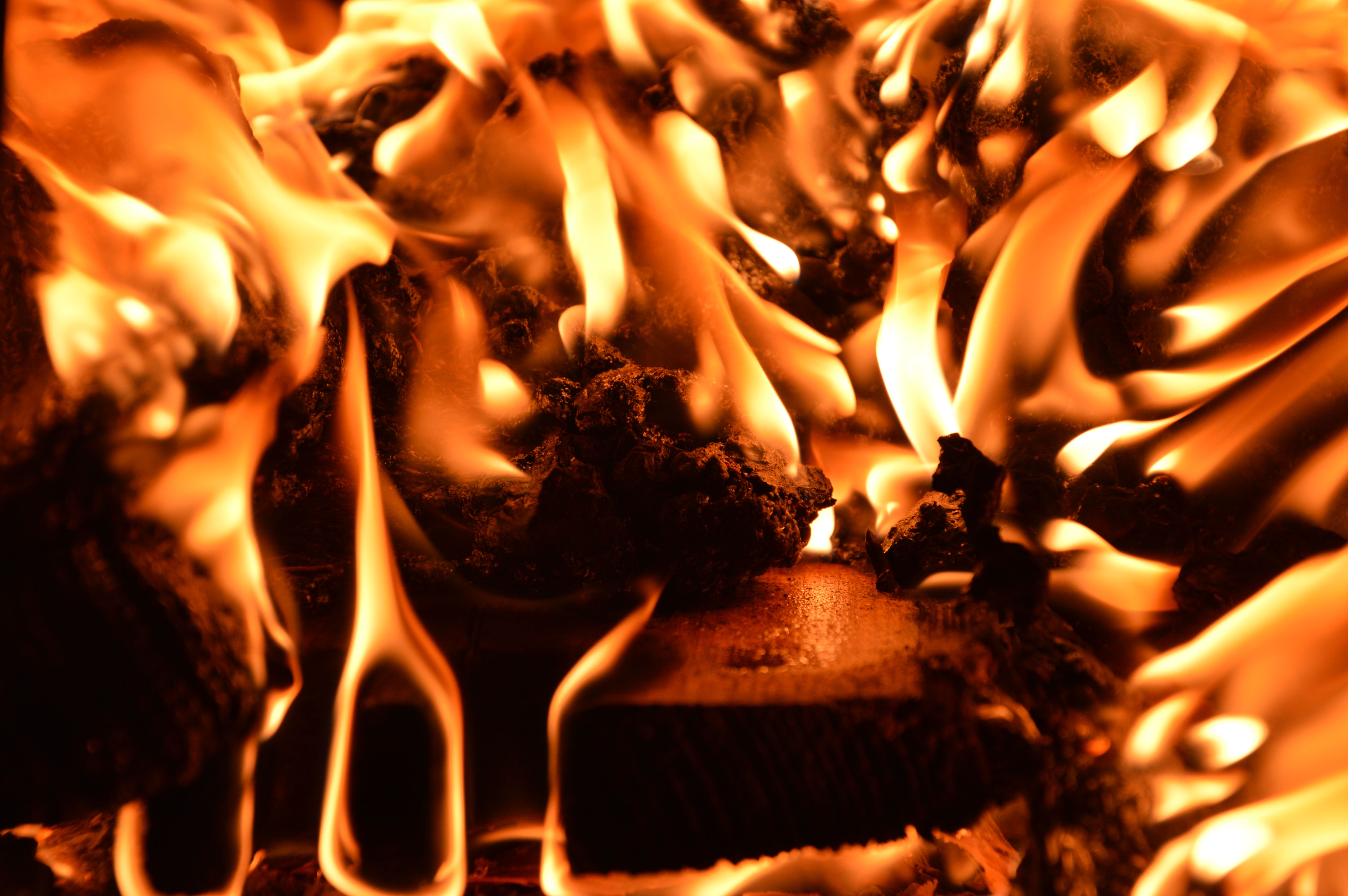 Close-up view of intense flames enveloping burning logs, creating a vivid and dramatic fire scene.