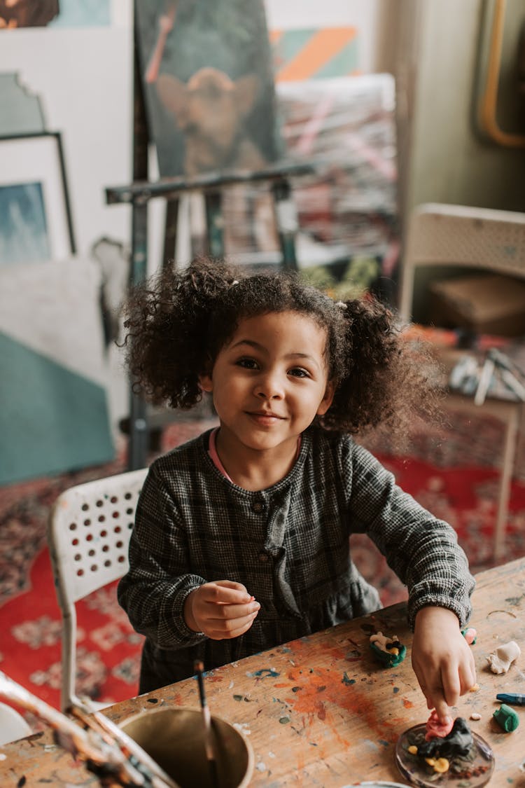 Little Girl Sculpting From Plasticine At The Wooden Table