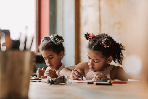 Little Girls Drawing at the Table