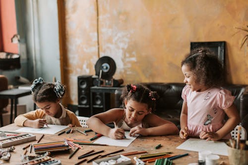 Three Girls Drawing at the Table