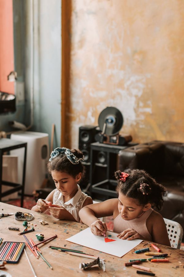 Two young girls drawing at a table