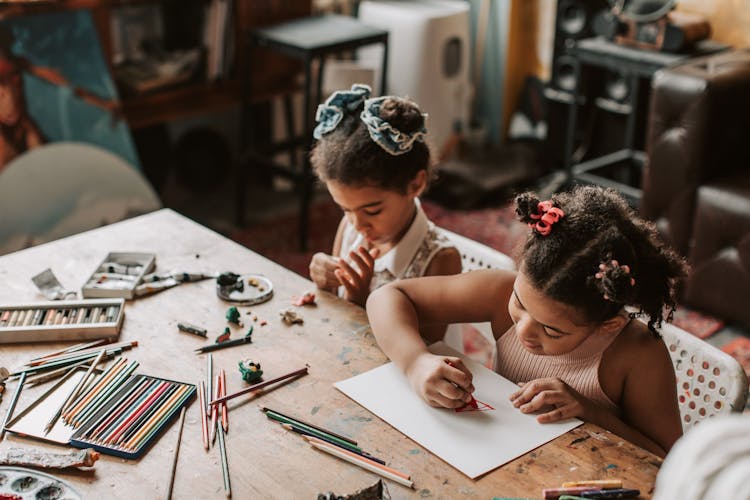 Little Girls Drawing At The Table