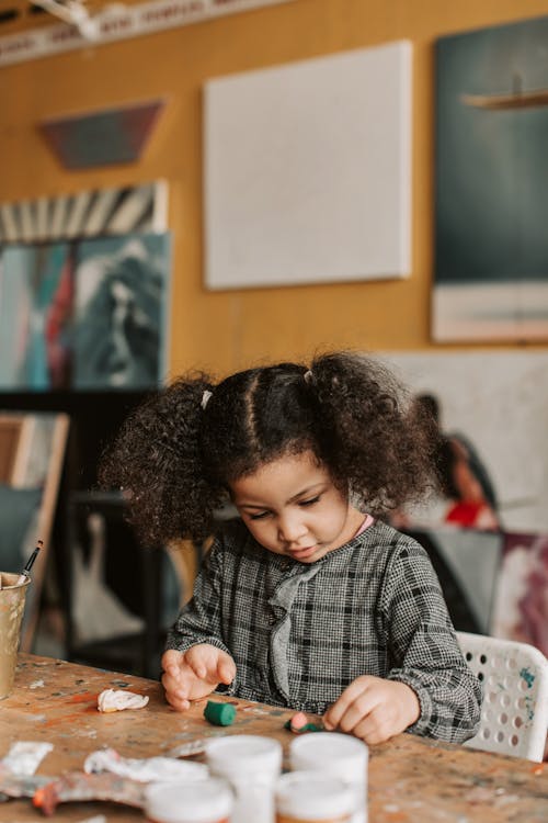 Photo of a Girl Playing with Clay