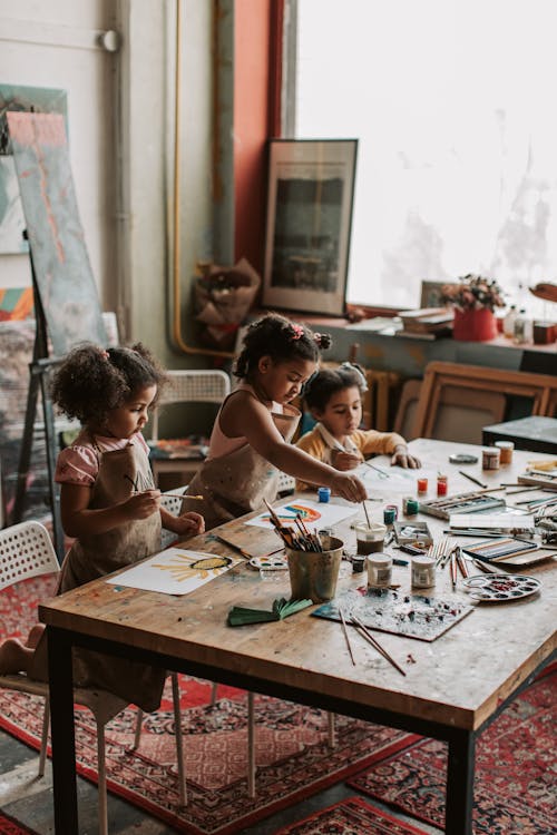 Girls Painting on Brown Wooden Table