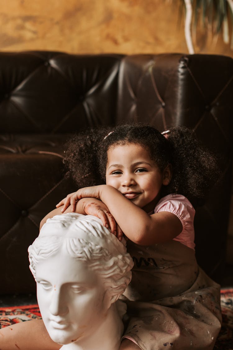 Little Girl Leaning On A Head Bust