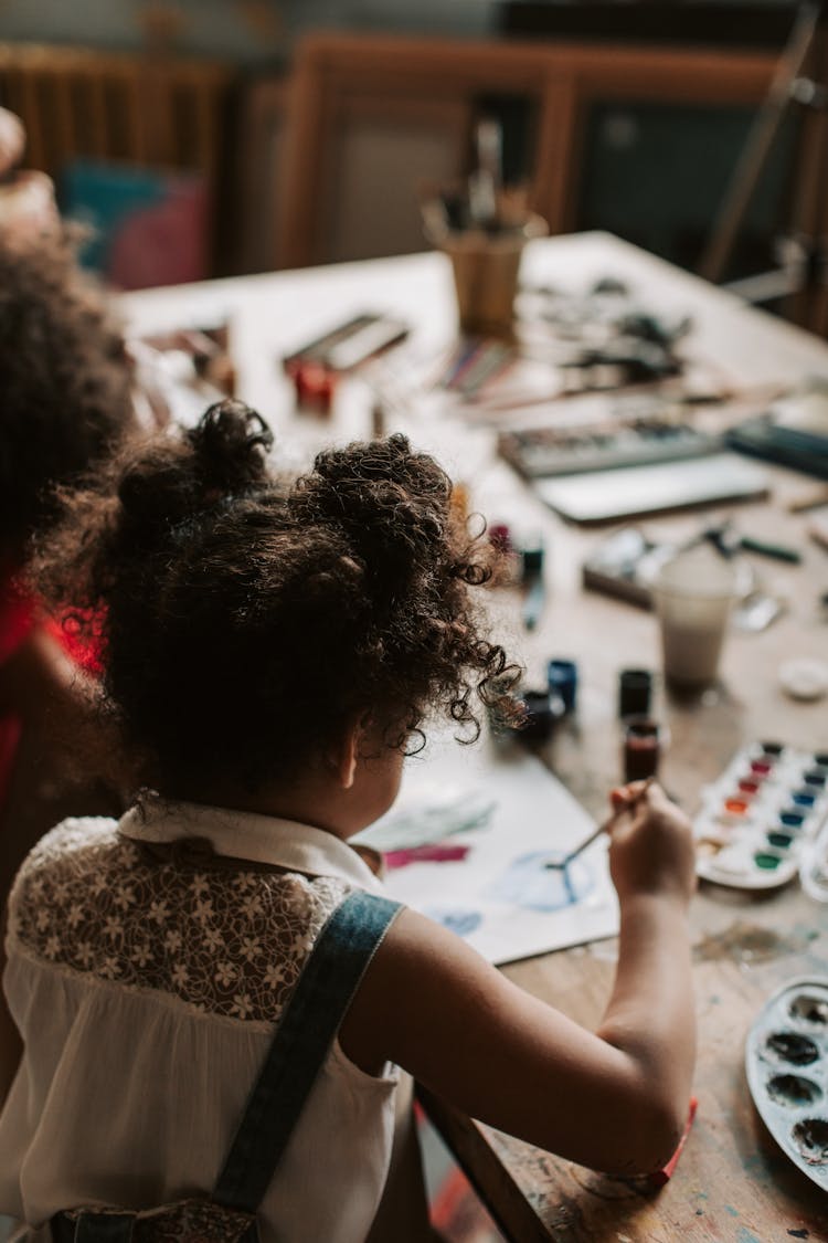 A Kid Making A Painting Using Watercolor