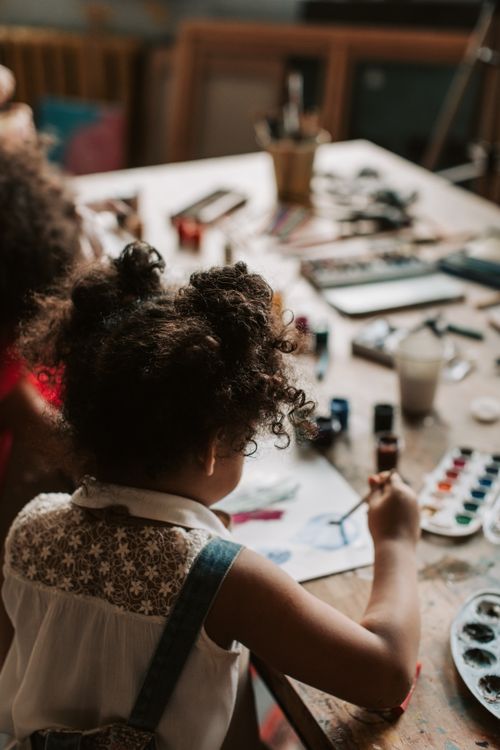 Free A child painting with watercolors at an indoor art studio. Stock Photo