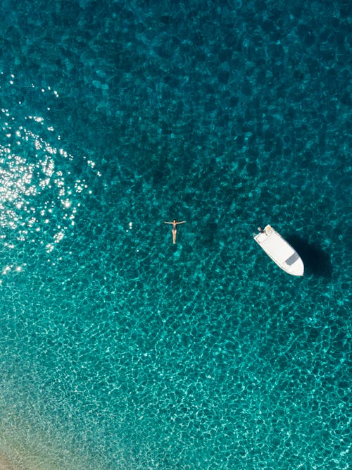 Drone Shot of a Woman Floating on the Sea