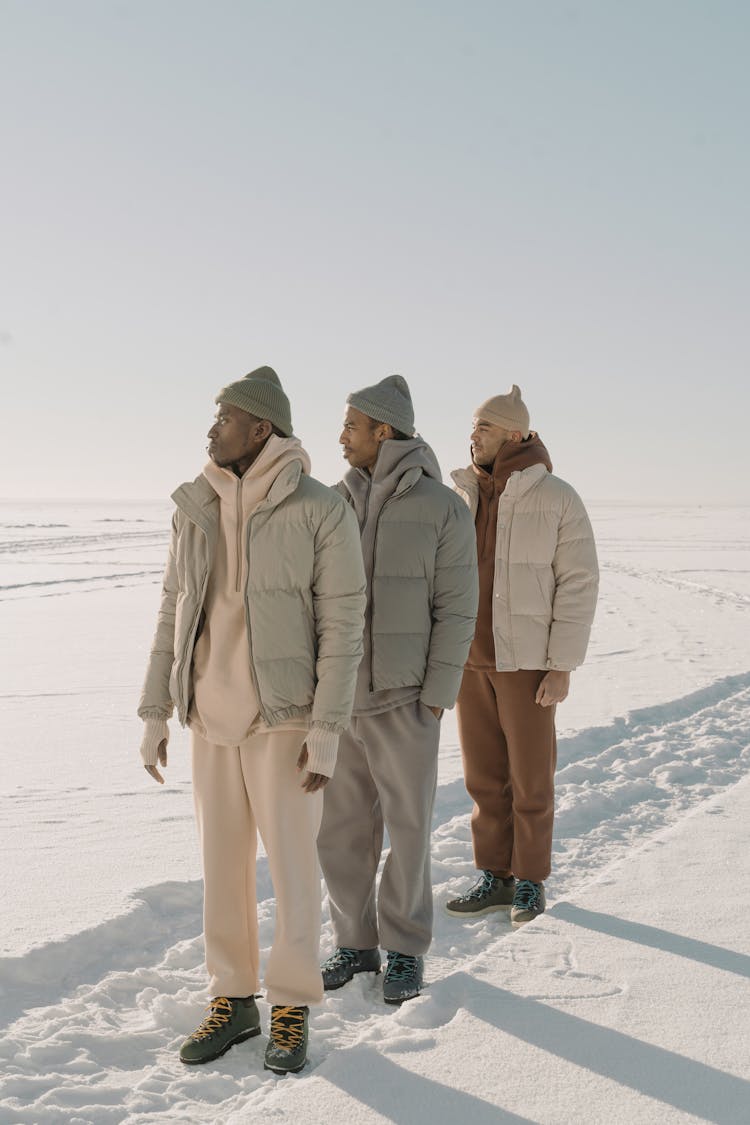 Photo Of Men In Puffer Jackets Standing On White Snow