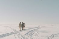 3 Person Walking on Snow Covered Field