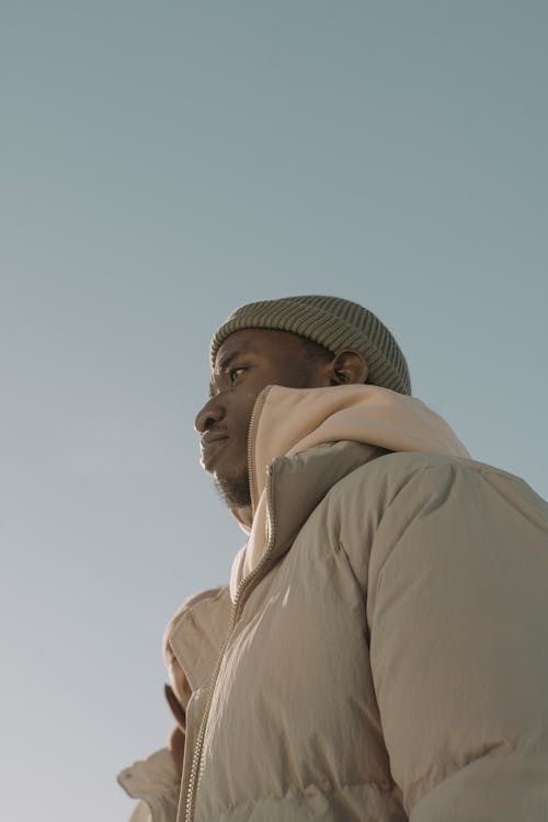 Low-Angle Shot of a Man Wearing a Green Puffer Jacket