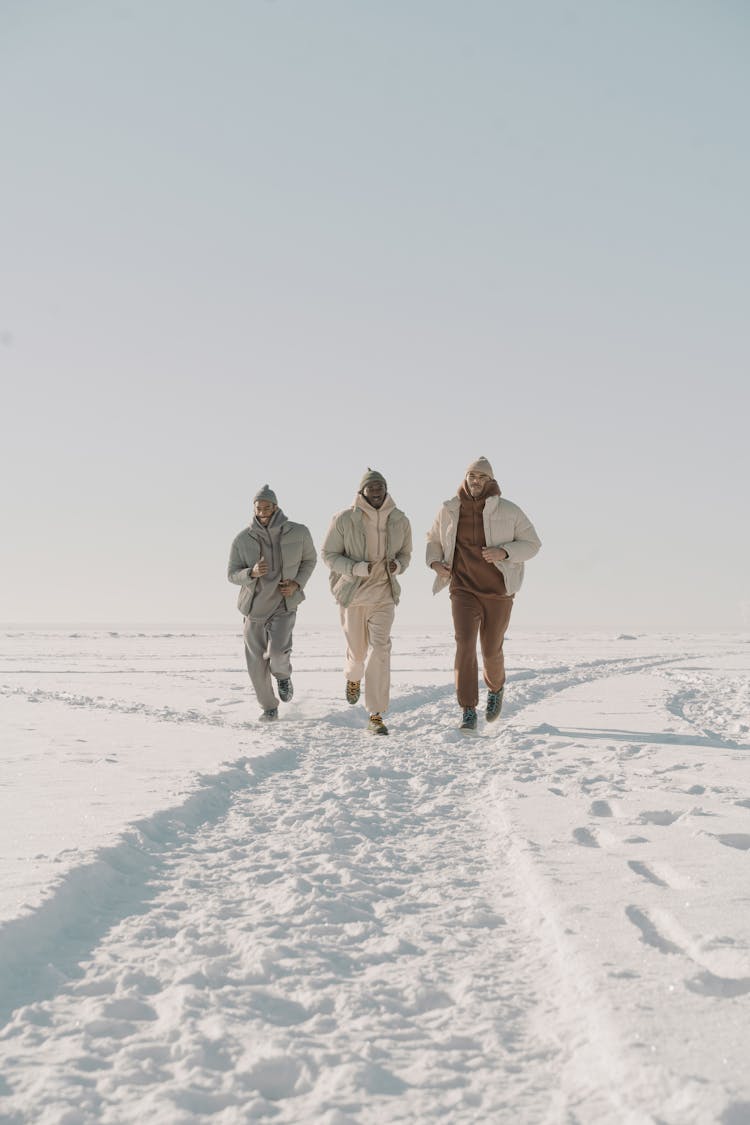 Photograph Of Men Running On The Snow