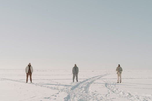 Three men in winter attire standing in a snowy landscape showcasing outerwear fashion.
