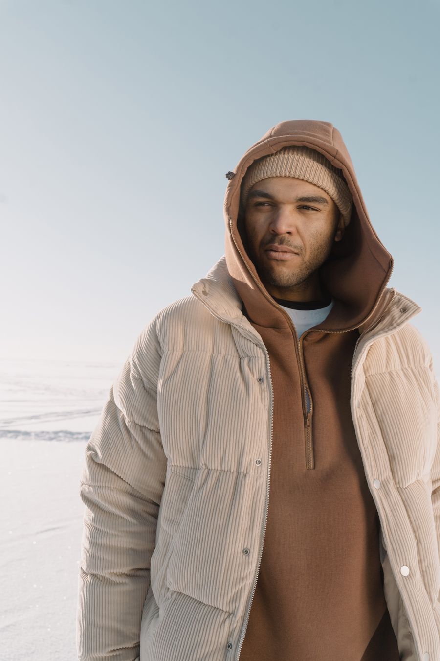 Hombre con hoodie y chaqueta en paisaje nevado