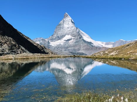 Body Of Water Near Mountain Under Clear Sky · Free Stock Photo