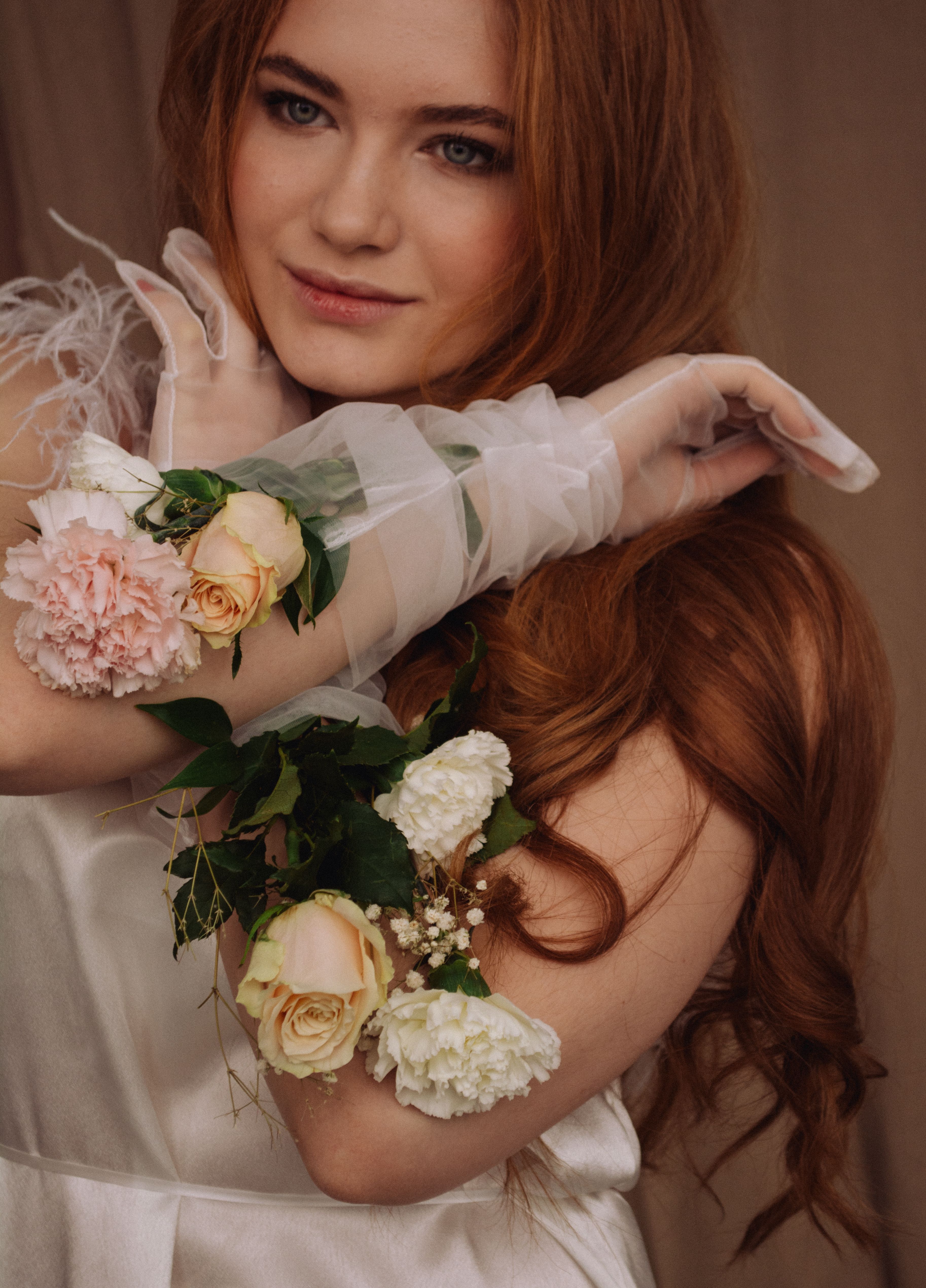 Beautiful portrait of a bride with flowing red hair and floral accessories.