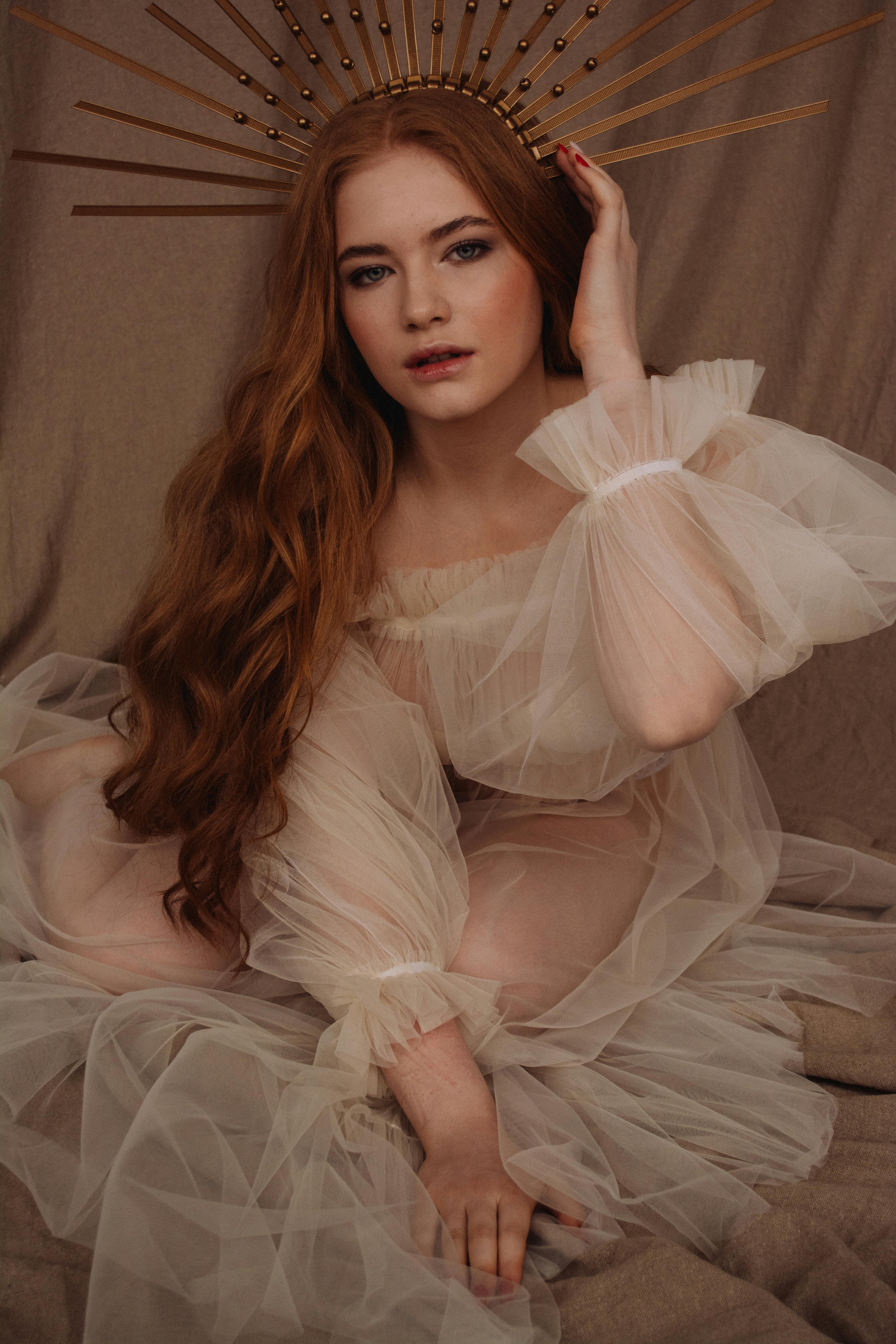 一位身穿精致薄纱连衣裙、留着长发、头戴金色头饰的女子肖像