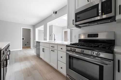 Free Bright, sleek kitchen interior featuring stainless steel appliances and white cabinetry for a modern design. Stock Photo