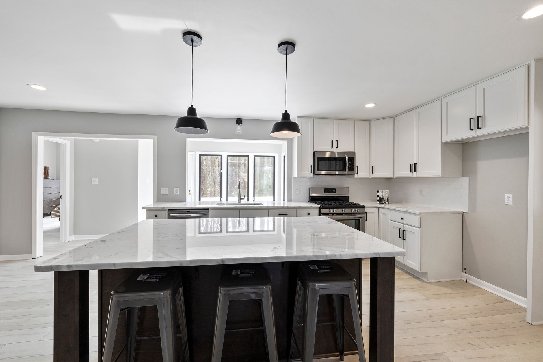 A bright, elegant modern kitchen with a marble island and sleek stainless steel appliances, ready for renovation. A bright, elegant modern kitchen with a marble island and sleek stainless steel appliances, ready for renovation.