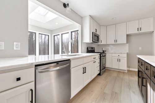 Free Bright contemporary kitchen with sleek stainless steel appliances and ample natural light. Stock Photo
