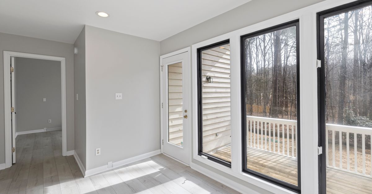 Spacious and bright room with large glass windows overlooking a serene outdoor setting.