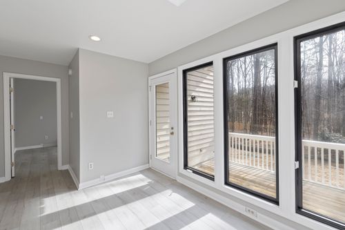 Free Spacious and bright room with large glass windows overlooking a serene outdoor setting. Stock Photo