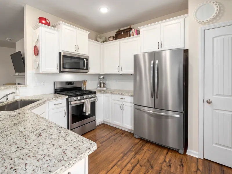 Modern kitchen with white cabinets and a stainless refrigerator where we fix water leaks Modern kitchen with white cabinets and a stainless refrigerator where we fix water leaks