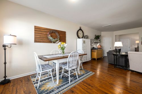 Free Spacious dining room with wooden table and chairs, accentuated by rustic decor and warm lighting. Stock Photo