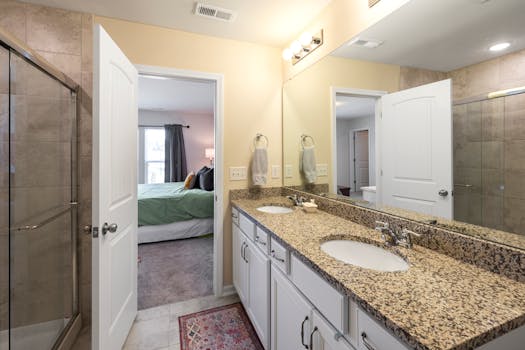 A stylish bathroom featuring a granite countertop and shower in a contemporary home.