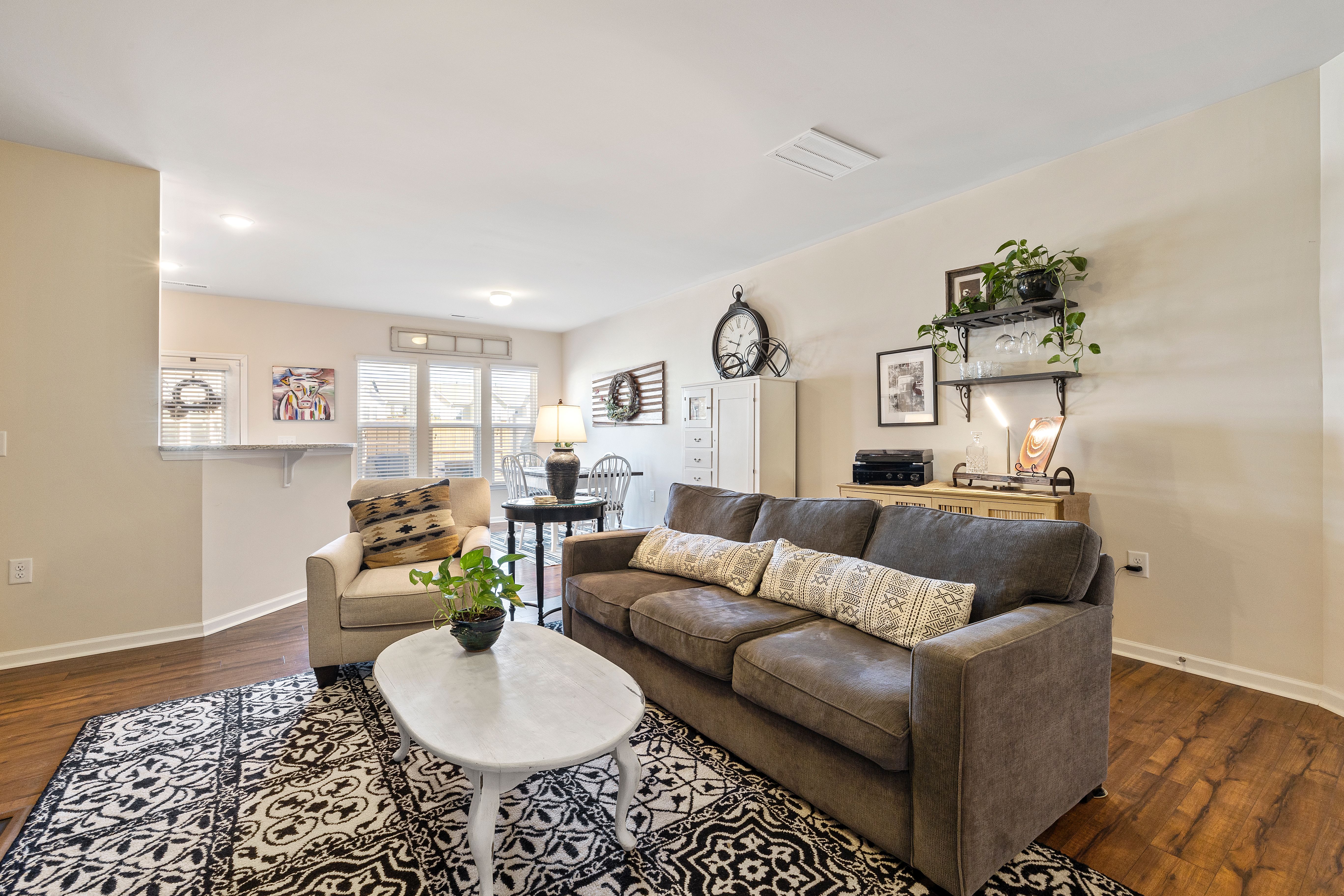 Living room with a brown sofa, white coffee table and wooden flooring
