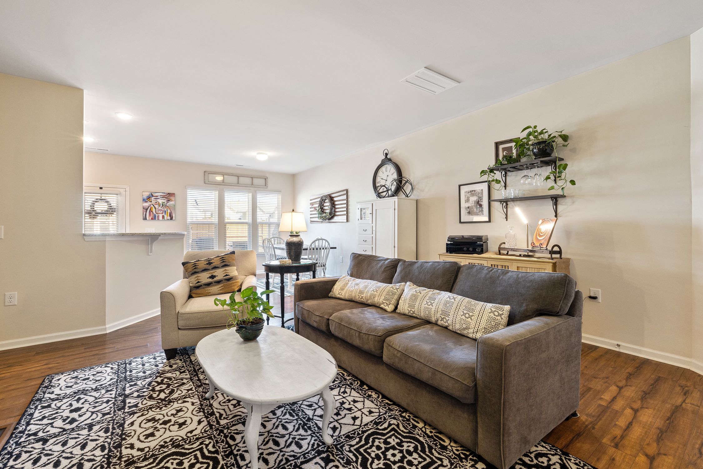 Living room with a brown sofa, white coffee table and wooden flooring