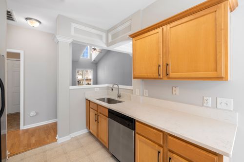Free Bright kitchen featuring light wood cabinets and marble countertop with stainless steel fixtures. Stock Photo
