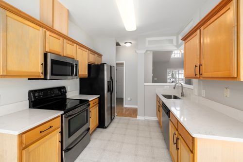 Free Spacious kitchen featuring wooden cabinets, modern appliances, and a bright ambiance. Stock Photo