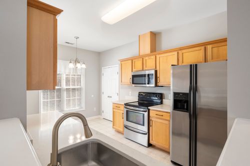 Free A bright and modern kitchen interior featuring stainless steel appliances and wooden cabinets. Stock Photo