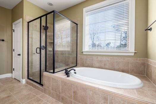Sleek modern bathroom featuring a glass shower and a relaxing bathtub with natural light.