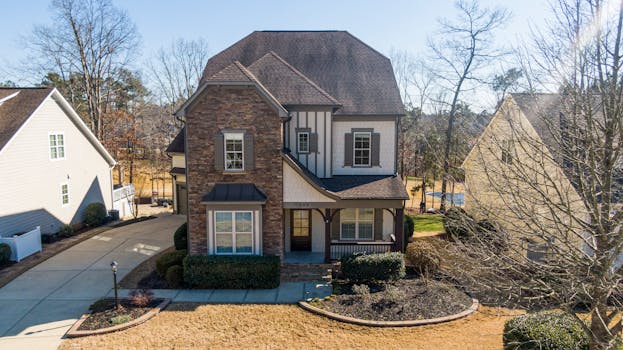 A beautiful two-story house with stone facade and lush yard in Holly Springs, NC.