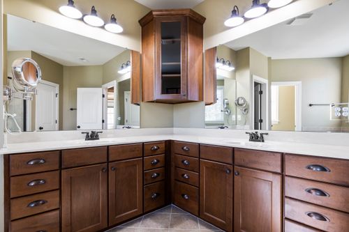 Free Spacious bathroom featuring wooden cabinets, large mirrors, and elegant lighting for a contemporary feel. Stock Photo