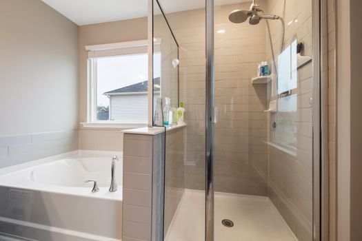 A contemporary bathroom featuring a glass shower and luxurious bathtub for stylish home design.