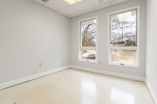 Spacious unfurnished room with natural light and large windows.