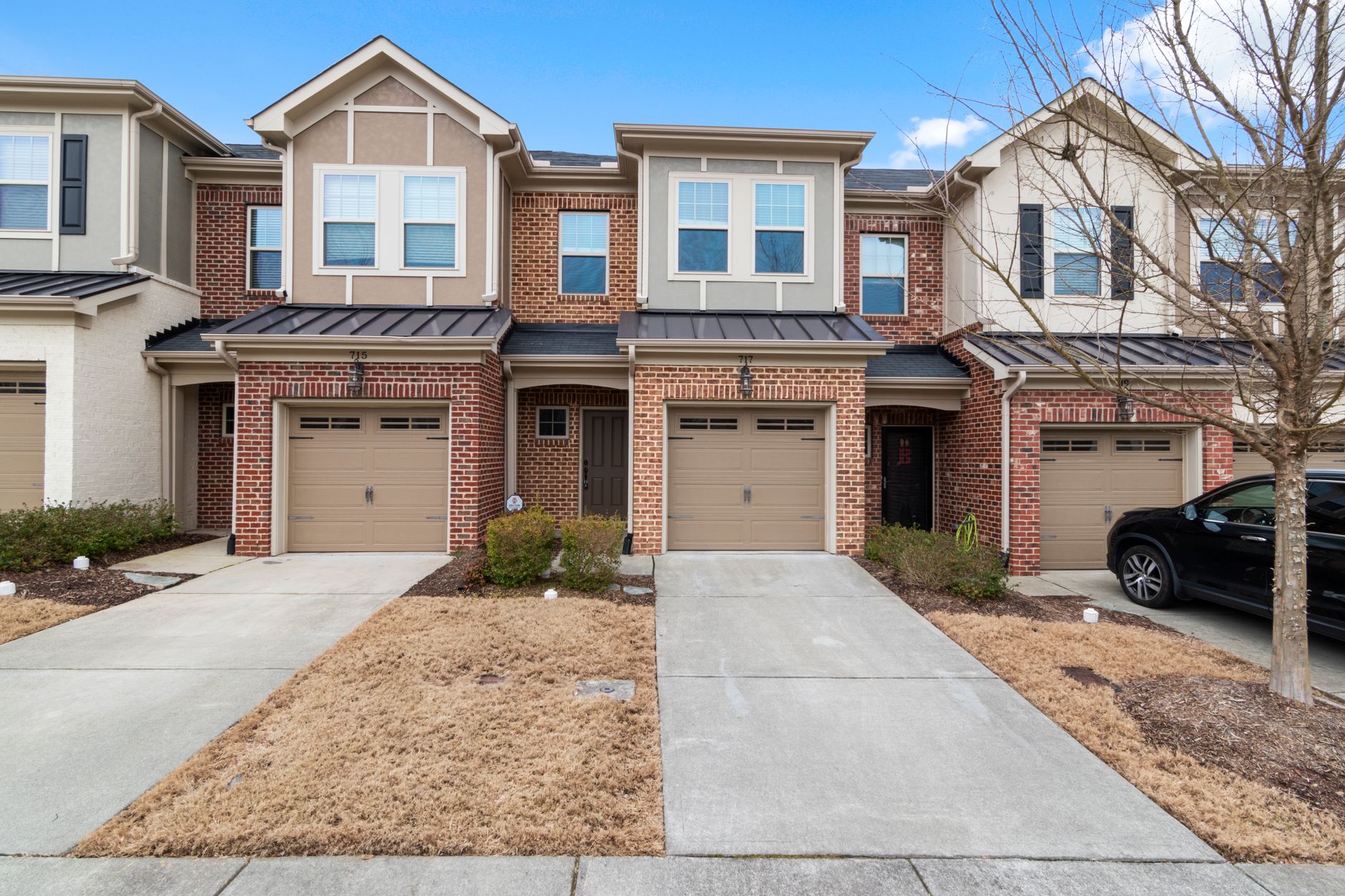 Elegant suburban brick townhouses with driveways in an upscale neighborhood.